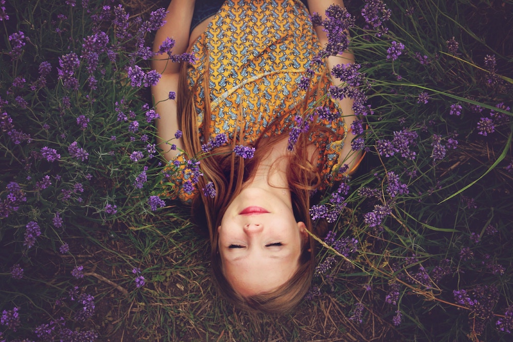 Learning to Choose Better Thoughts | Happy As Annie - We can't control our thoughts, but we can choose better thoughts to engage in and listen to. A mindfulness meditation practice can retrain our brains to choose better thoughts and reject unwanted or harmful ones. (Woman lying on ground on her back with eyes closed among purple flowers)