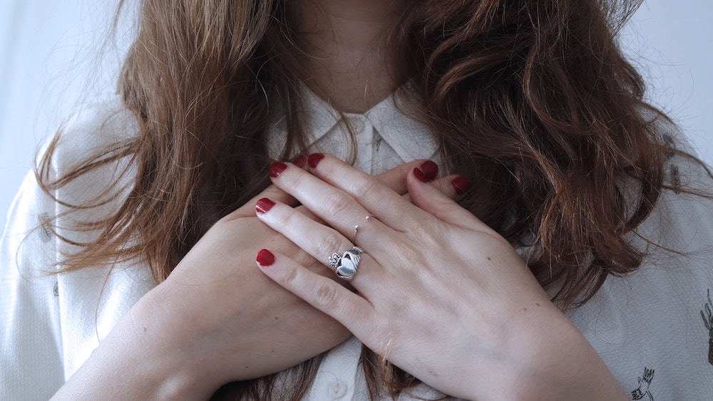 Ego or Intuition? How to Tell the Difference | Happy As Annie (Woman with red nail polish and clauddagh ring with hands crossed over her chest)