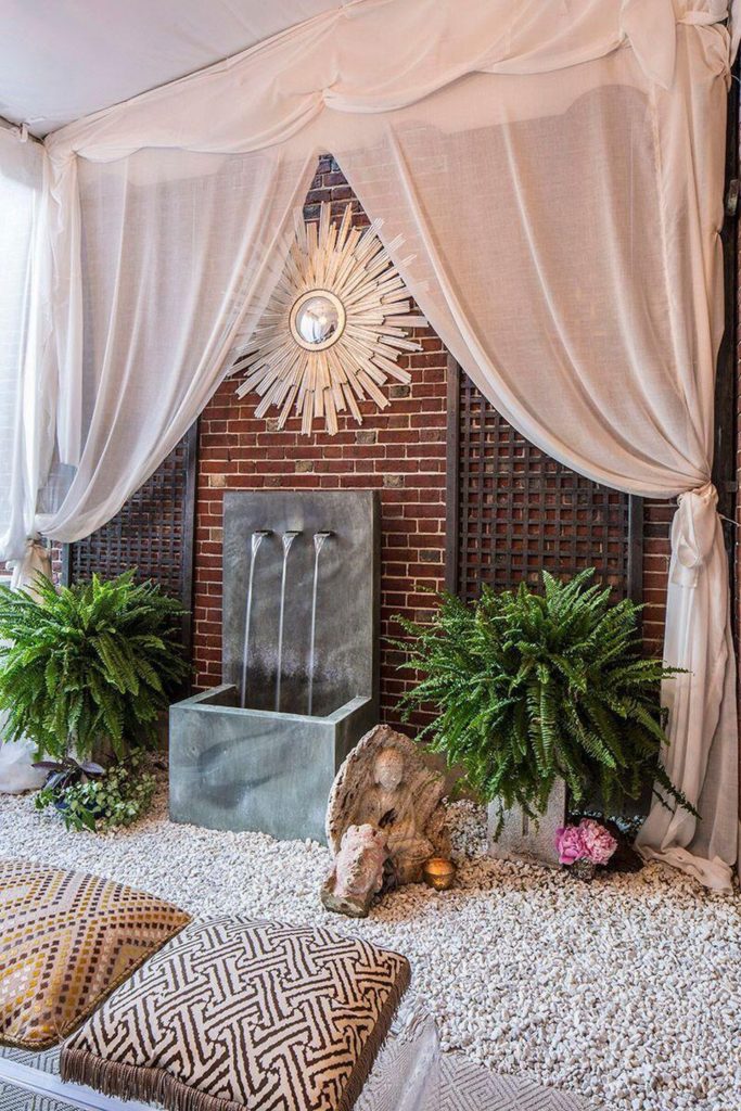 Happy As Annie | 7 Meditation Room from Pinterest You Ned to Copy - and how to get the look! (Water fountain and cushion pillows on gravel in outdoor space with exposed brickand drapes)
