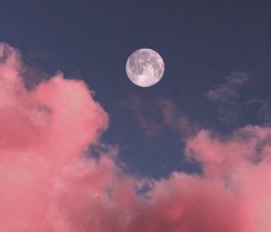 Full moon in blue sky with pink clouds