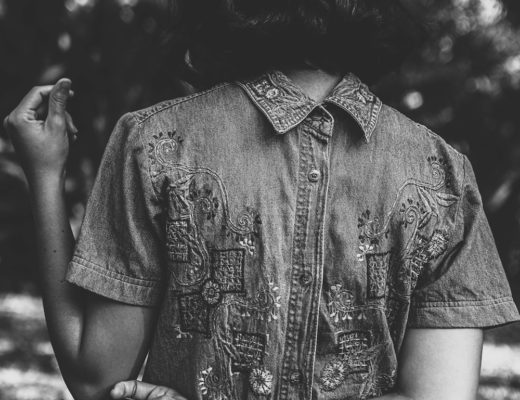 Woman wearing chambray dress with cross tattoo on wrist